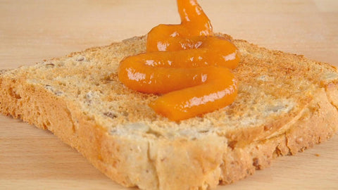 Zuckerreduzierte Aprikose GOFITÜRE wird schwunghaft auf ein Toastbrot aufgetragen. 